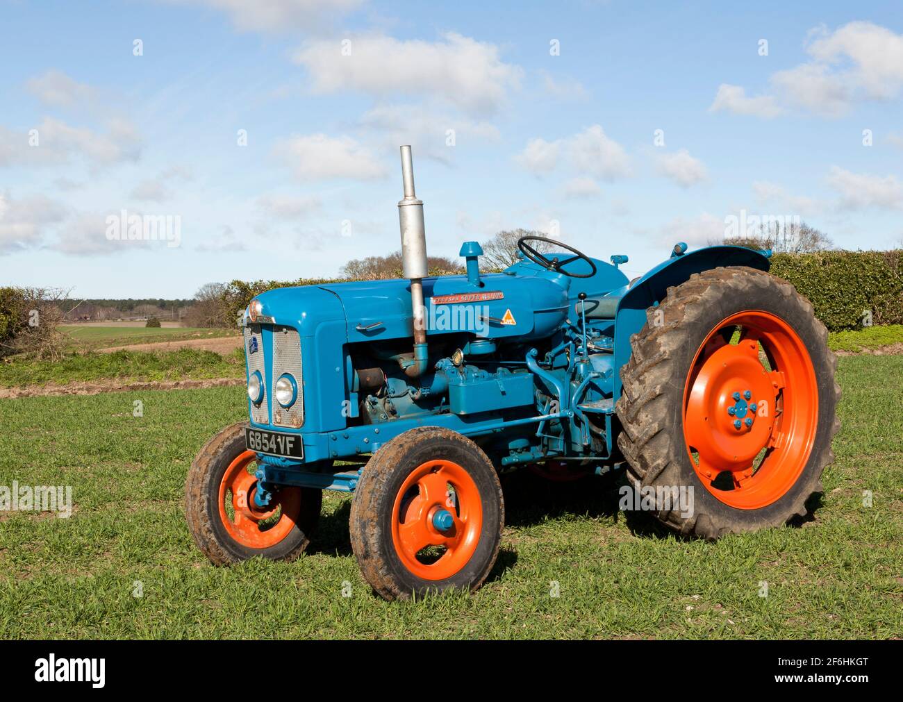 Fordson Super grand tracteur d'époque dans un champ percé avec Orge de printemps Banque D'Images