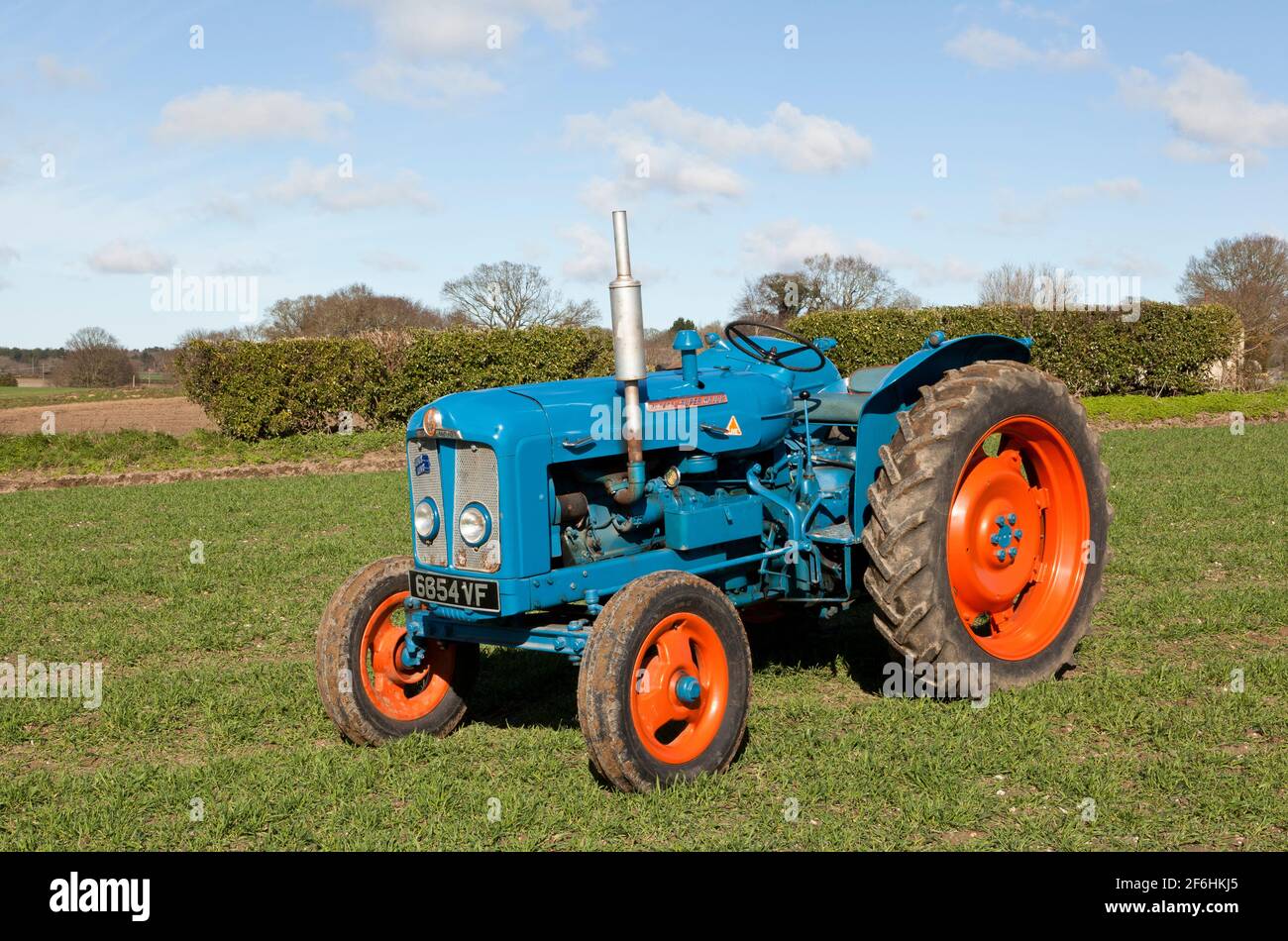 Fordson Super grand tracteur d'époque dans un champ percé avec Orge de printemps Banque D'Images