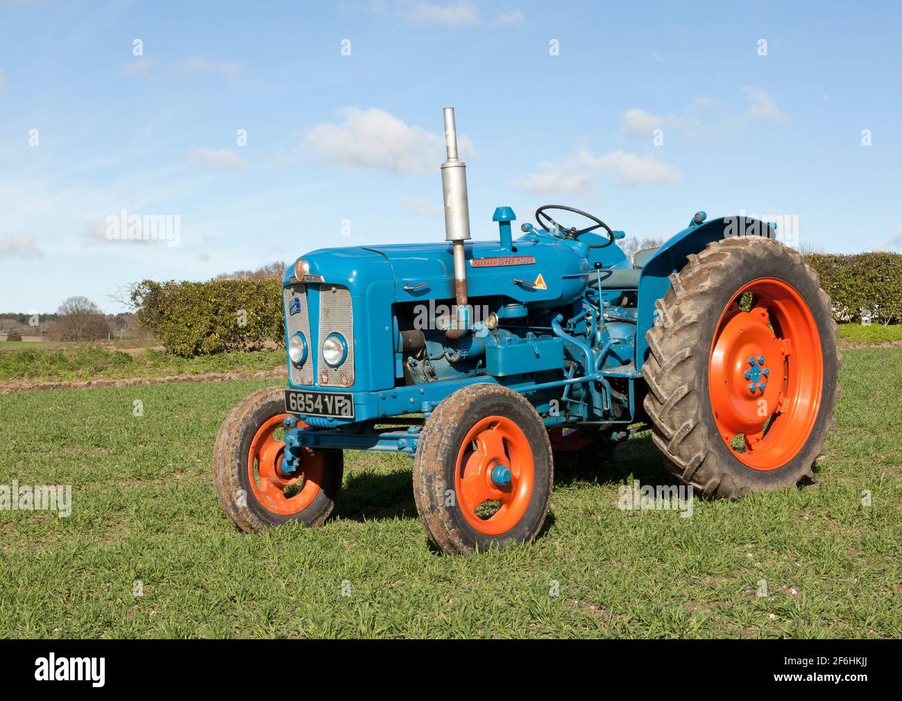 Fordson Super grand tracteur d'époque dans un champ percé avec Orge de printemps Banque D'Images