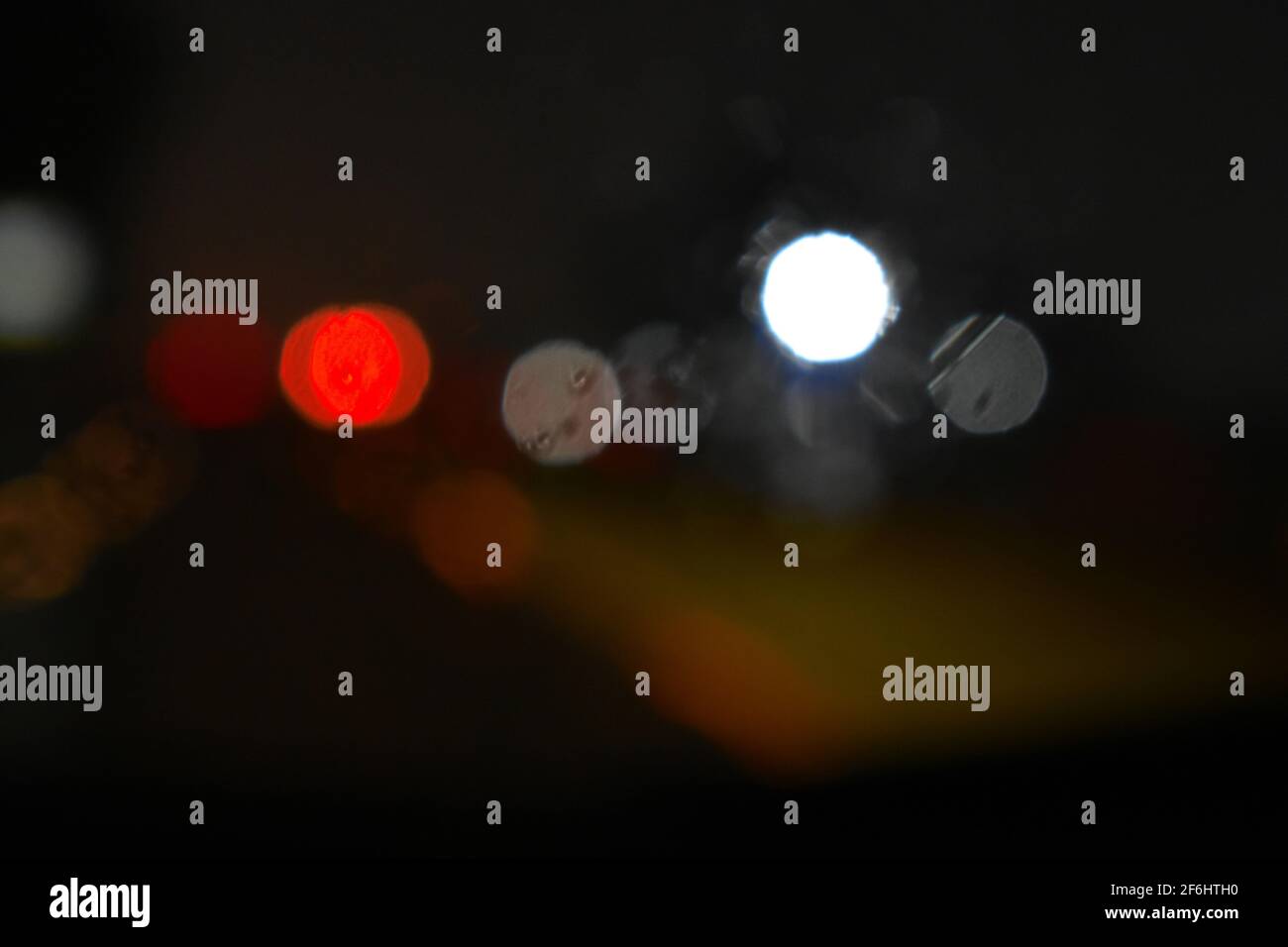 les lumières floues provenant des phares de voiture et des signaux pendant la conduite par la nuit pluvieuse. Pris lors des inondations de mars 2021 à Sydney Banque D'Images