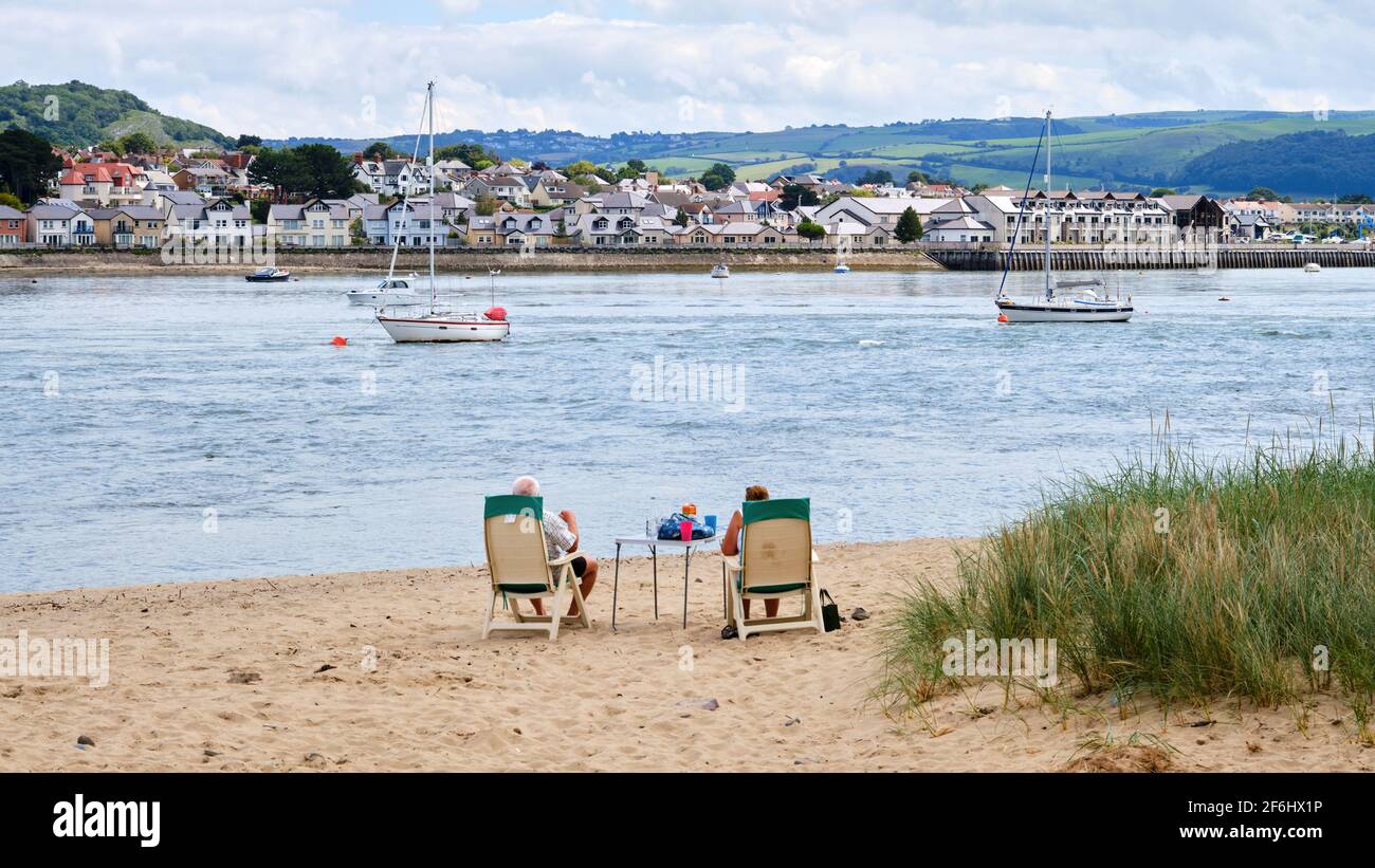 Un couple trouve l'endroit idéal pour profiter d'un pique-nique sur la plage et regarder l'activité sur la rivière Conway, au pays de Galles Banque D'Images