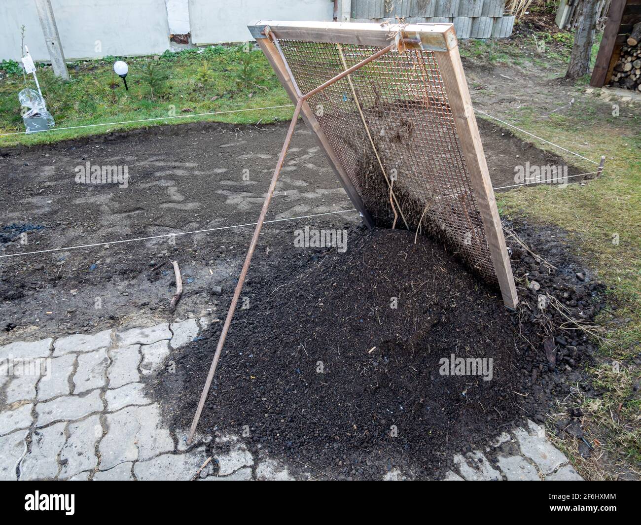 Tamisez le sol du jardin avec un tamis Banque D'Images