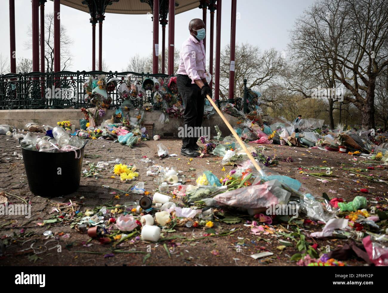 Un employé du conseil remet des hommages floraux à un mémorial de fortune pour la Sarah Everard assassinée du kiosque à musique Clapham Common Bandstand à Londres, en Grande-Bretagne, le 1er avril 2021. REUTERS/Hannah McKay Banque D'Images