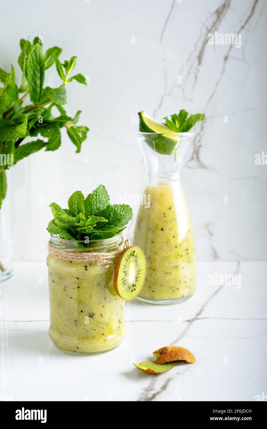 Smoothie vert sain avec banane, citron vert, pomme dans un pot en verre et ingrédients. Detox, régime alimentaire, sain, concept alimentaire végétarien. Banque D'Images