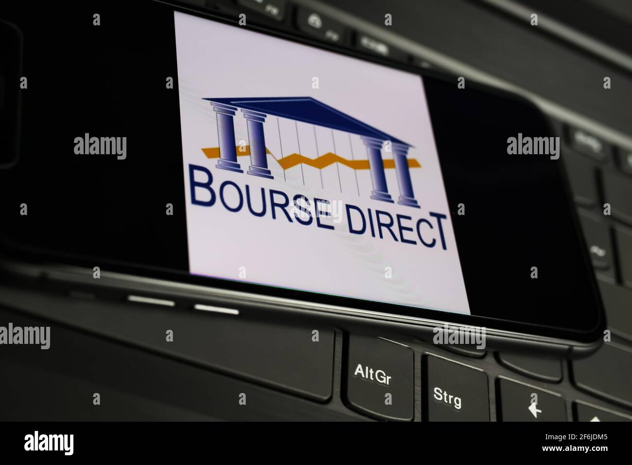 Viersen, Allemagne - 1er mars. 2021: Gros plan de l'écran du smartphone avec le logo du prestataire de services financiers français bourse directement sur la clé d'ordinateur Banque D'Images