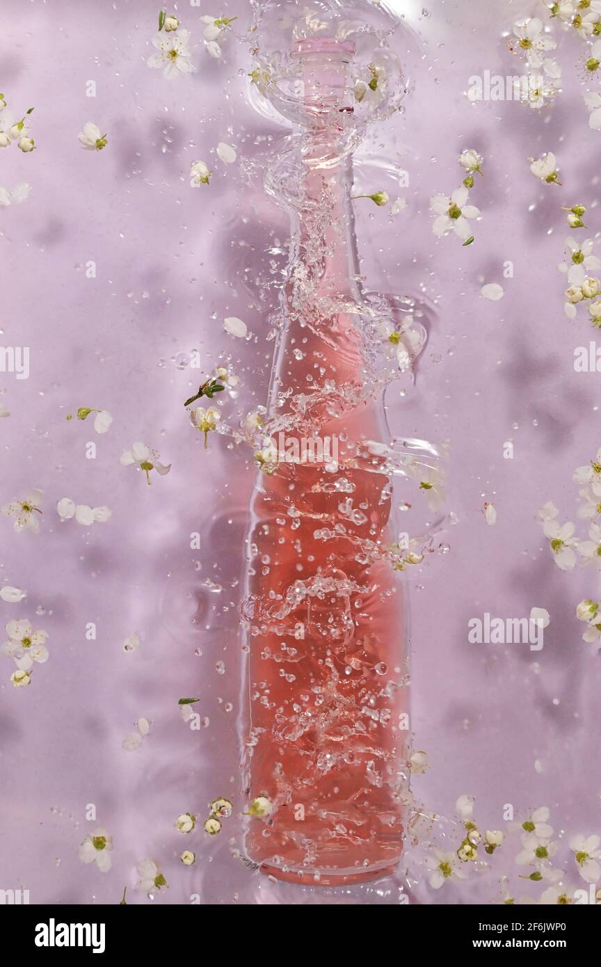 Bouteille de vin rose et fleurs printanières Banque D'Images