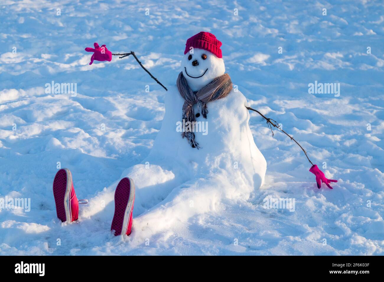 Un bonhomme de neige portant un chapeau et une écharpe rouges. Banque D'Images