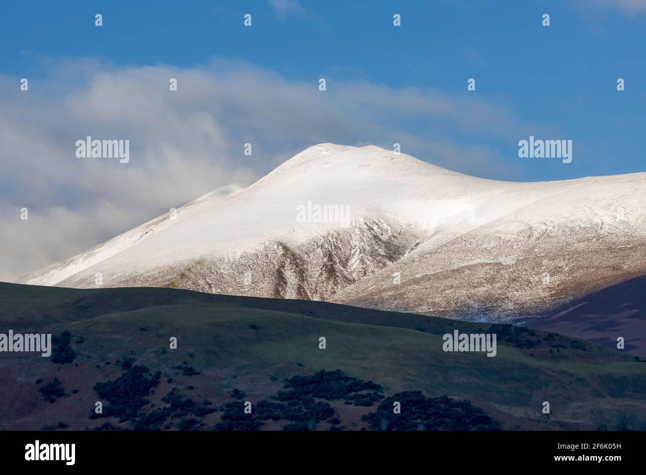 Skiddaw, parc national de Lake District, Cumbria. Les marcheurs peuvent être vus sur le sentier escarpé du sommet même par une journée enneigée en décembre. Banque D'Images