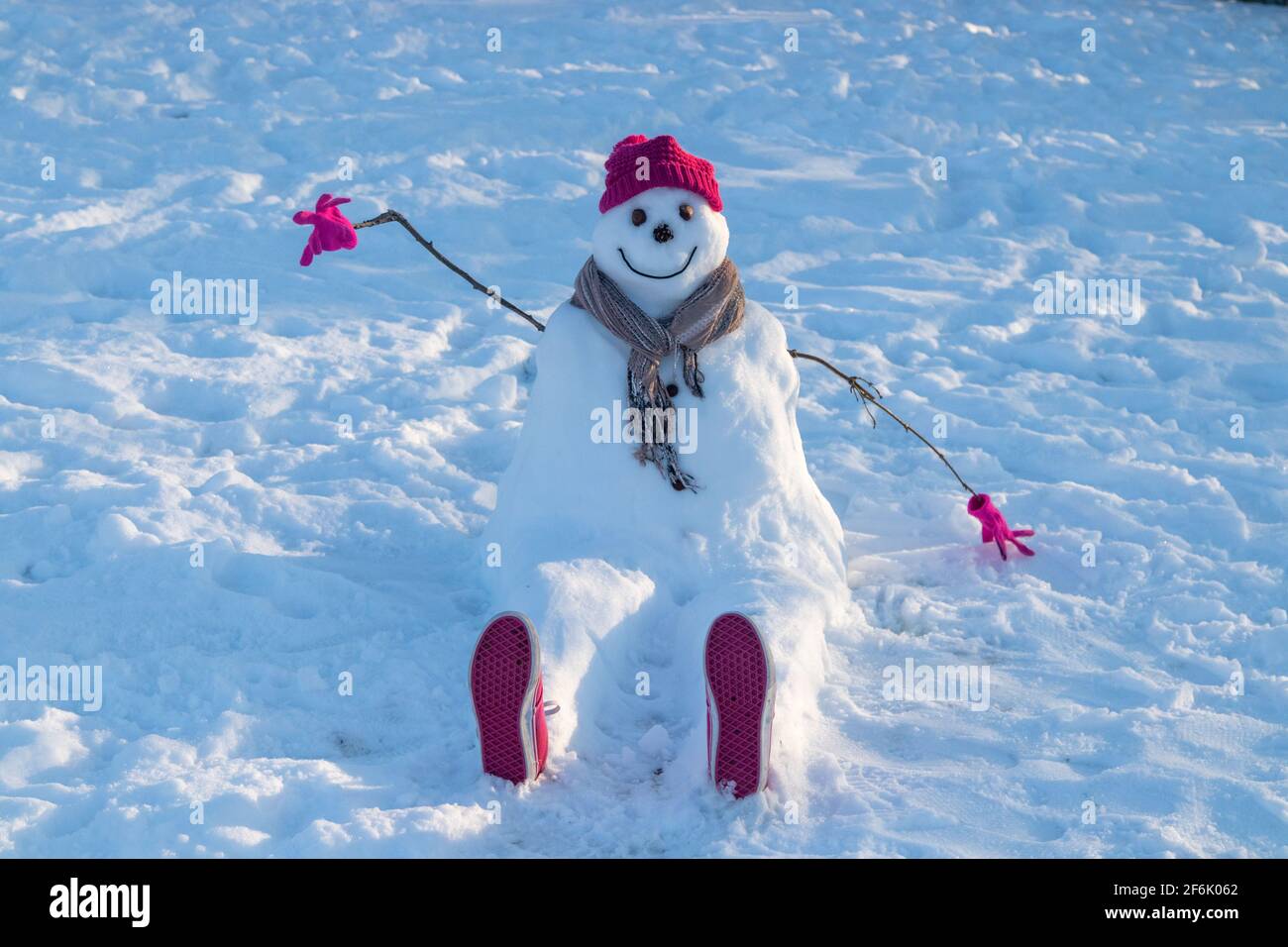 Un bonhomme de neige portant un chapeau et une écharpe rouges. Banque D'Images