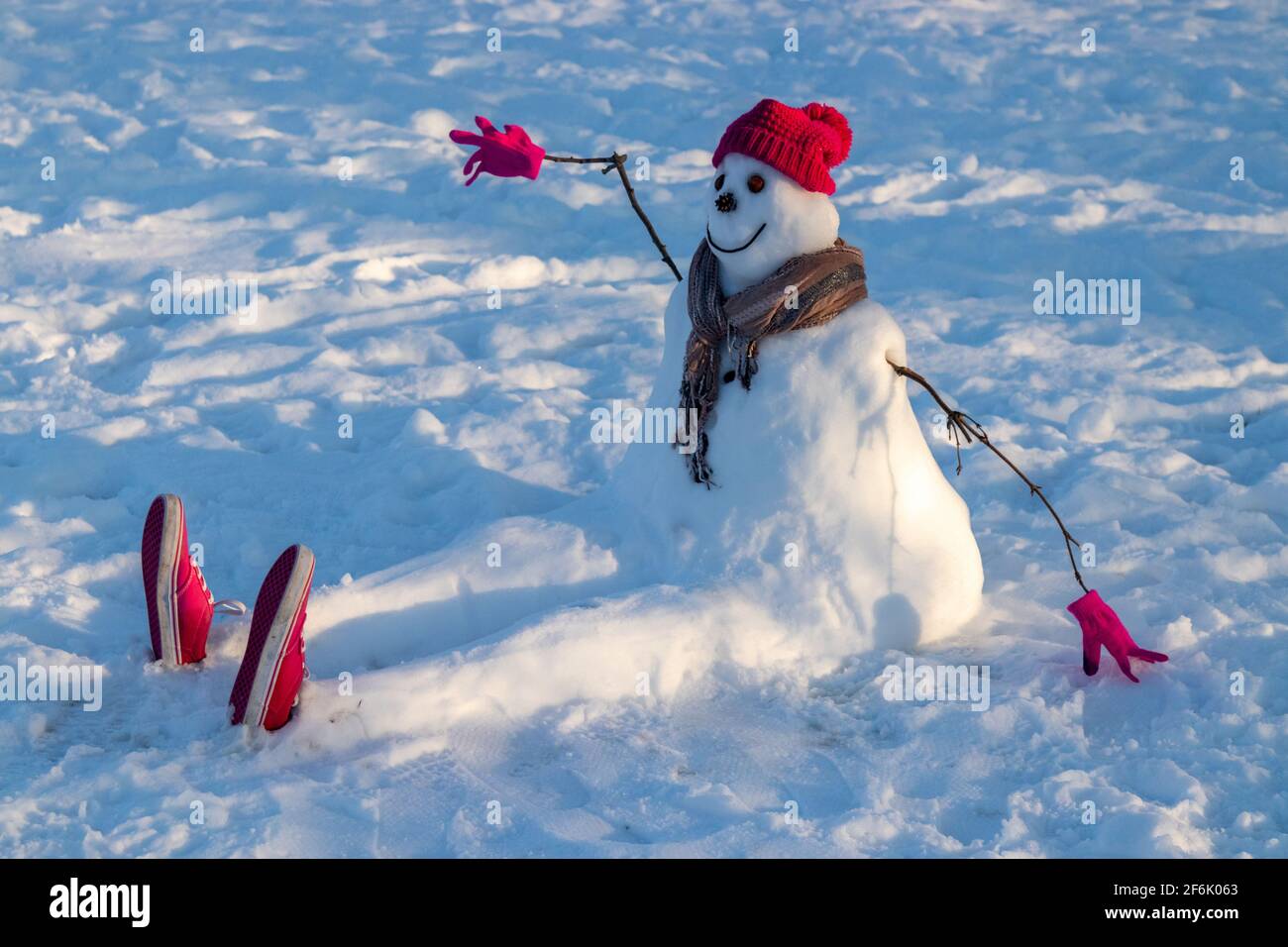 Un bonhomme de neige portant un chapeau et une écharpe rouges. Banque D'Images