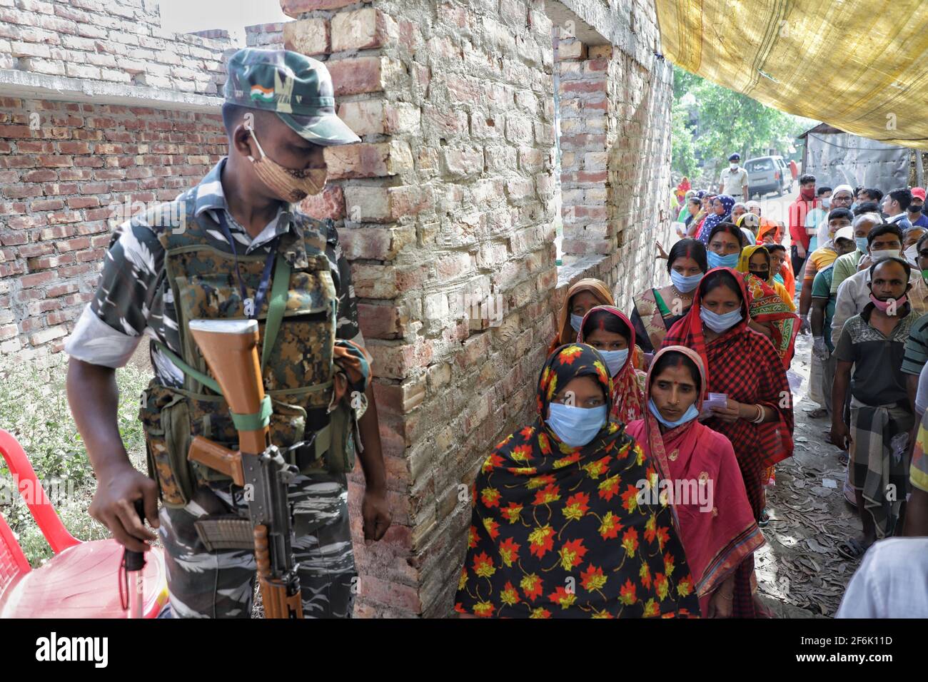 Un officier de la force centrale armée se trouve sur la porte d'entrée d'un stand électoral à East Midnapur.les électeurs de Nandigram ont voté lors de la deuxième phase des élections de l'assemblée du Bengale occidental sous le déploiement de forces centrales armées lourdes pour rendre les élections pacifiques. Banque D'Images