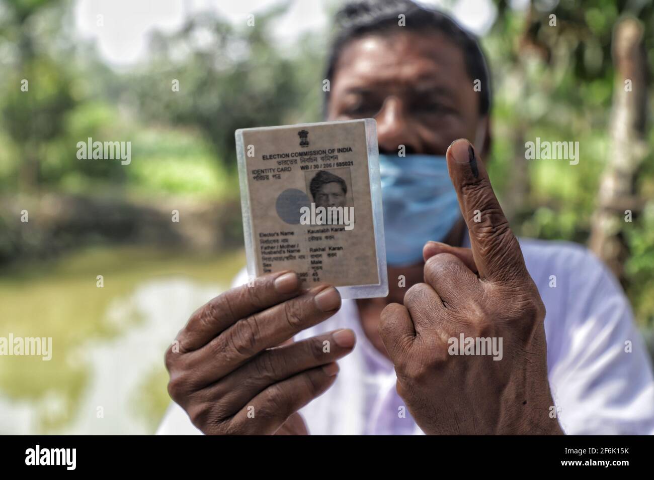 Un homme montre son doigt enchassé et la carte d'identité de l'électeur après avoir voté à East Midnapur.les électeurs de Nandigram ont voté lors de la deuxième phase des élections d'assemblée du Bengale occidental sous le déploiement de forces centrales armées lourdes pour rendre les élections pacifiques. Banque D'Images