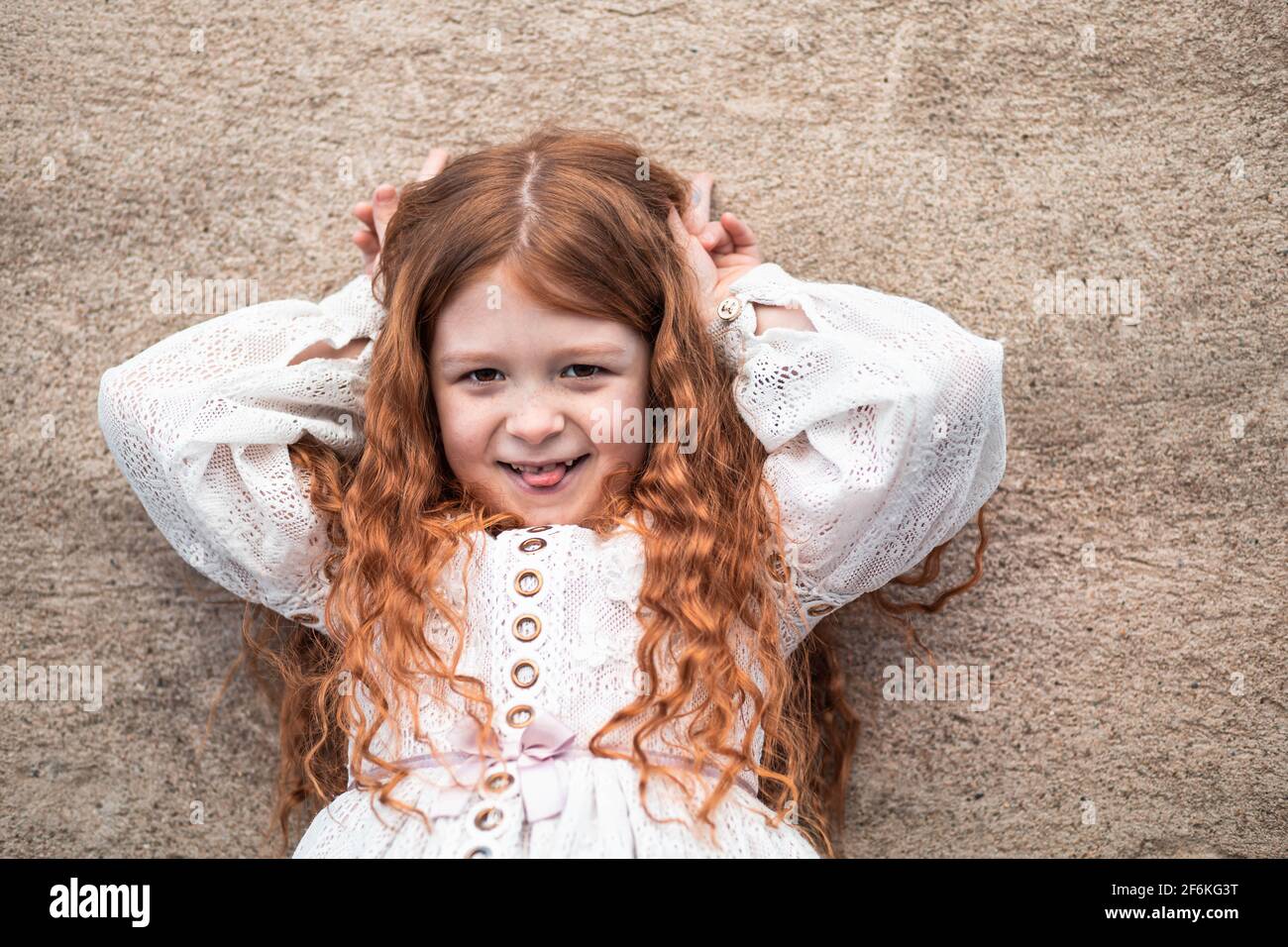 Portrait d'une petite fille au gingembre mignonne qui colle à la langue Banque D'Images