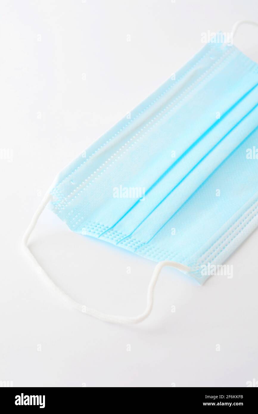 Masque chirurgical bleu (actuellement protégeant contre le coronavirus Covid-19) sur fond blanc. Banque D'Images