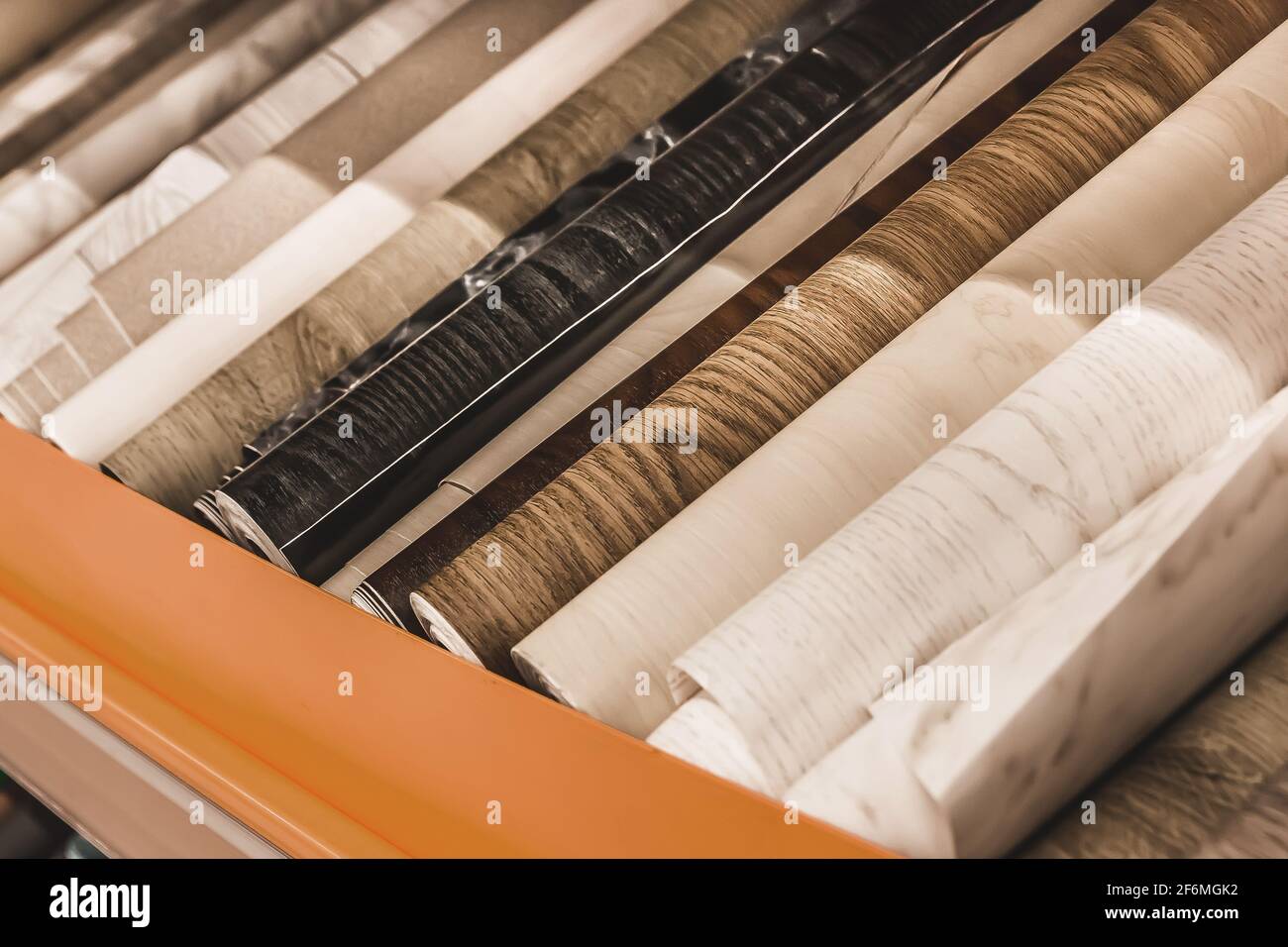 Assortiment de papier peint clair et foncé en rouleaux avec un motif abstrait dans un magasin de quincaillerie. Banque D'Images