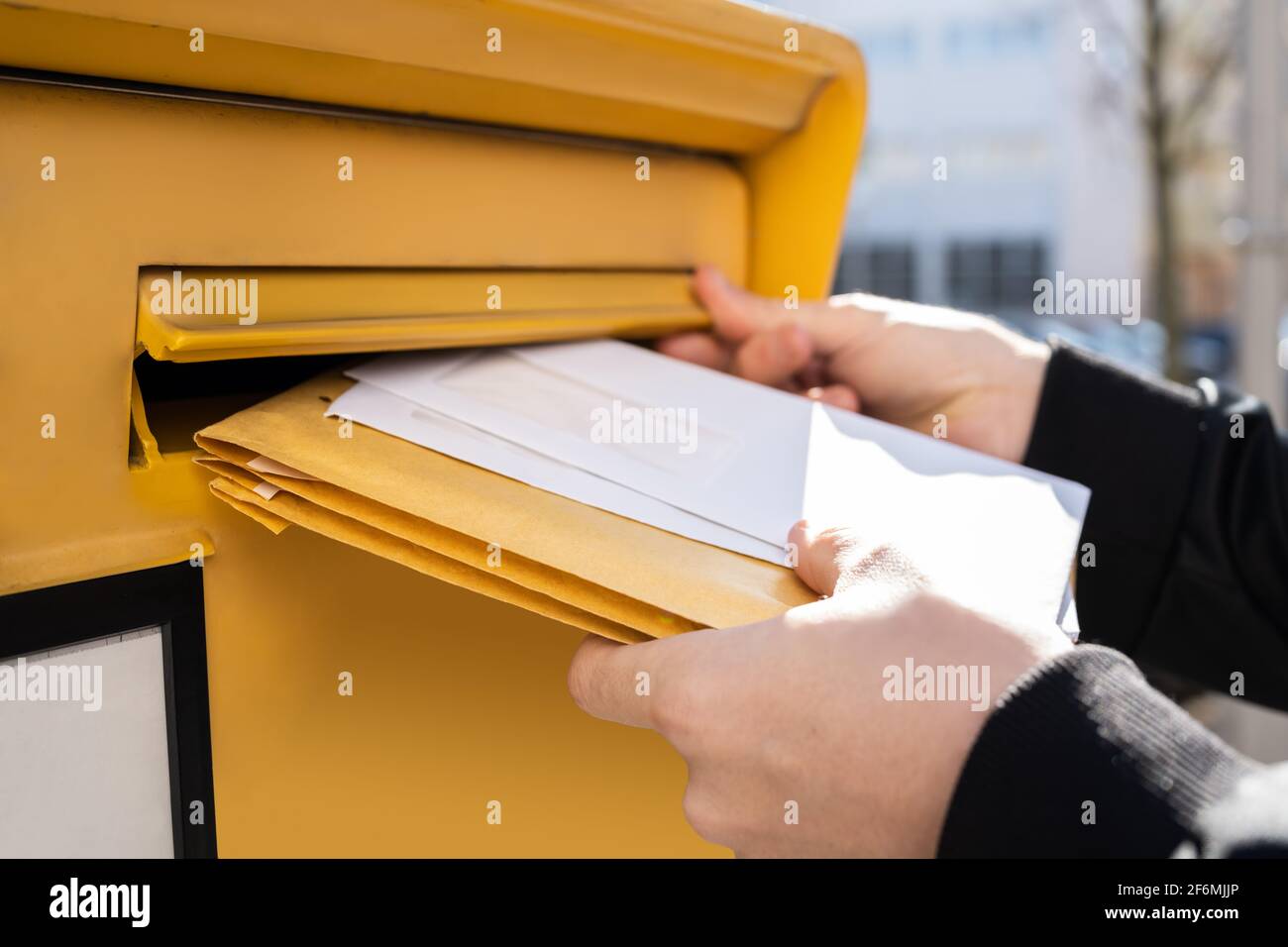 Lettre dans l'enveloppe ou document dans la boîte aux lettres. Homme main envoyant le courrier Banque D'Images