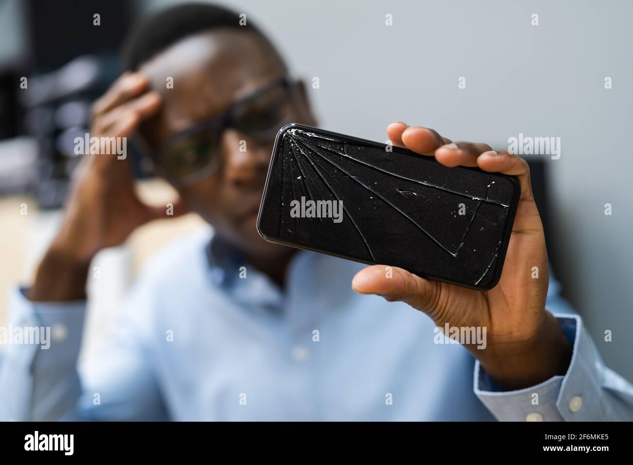 Téléphone cassé fissuré. Réparation de smartphone. Expression inquiète Banque D'Images