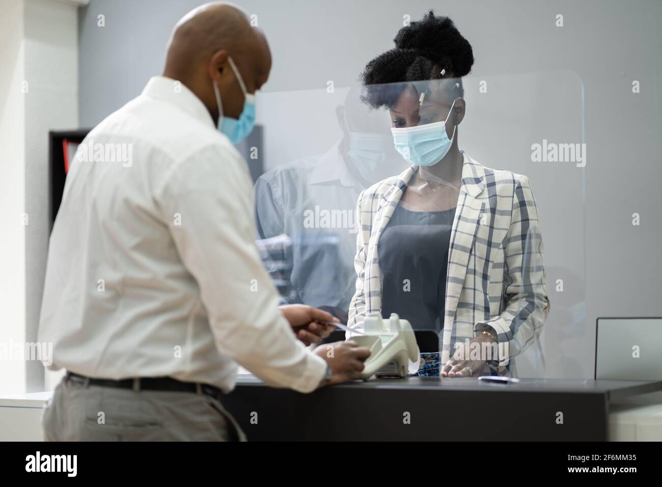 Caissier de la boutique ou réception de l'hôtel avec masque médical Banque D'Images