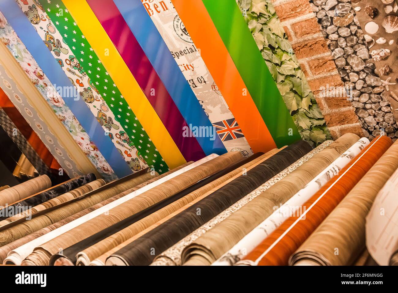 Belarus, Minsk - 19 décembre 2019: Différents échantillons de papier peint couleur en rouleaux pour la conception intérieure dans le magasin. Banque D'Images