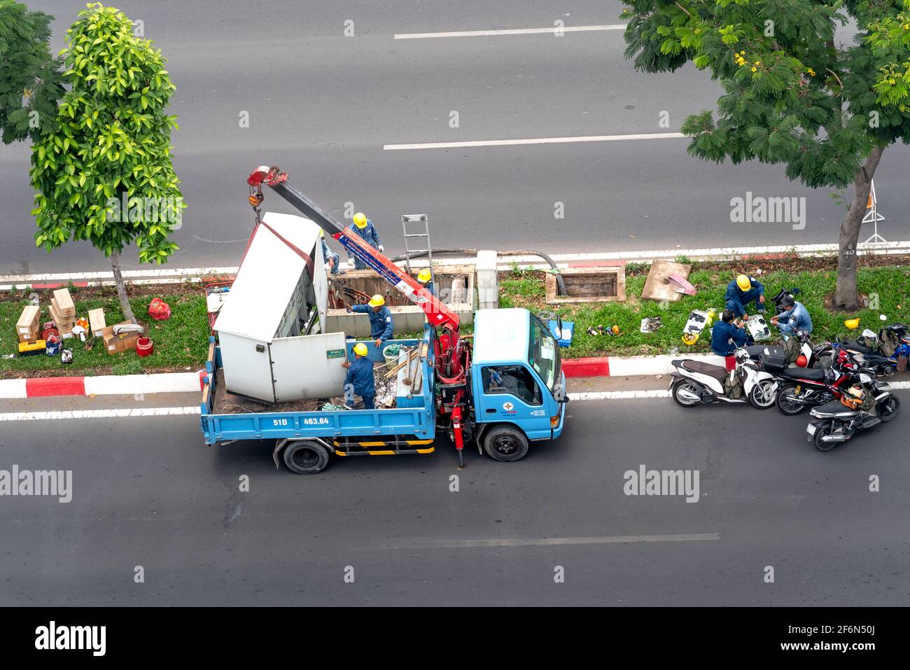 Pham Van Dong Street, quartier 3, Go VAP District, Ho Chi Minh ville, Vietnam - 31 mars 2021: Des techniciens électriques réparent les câbles souterrains sur Pham Van Banque D'Images