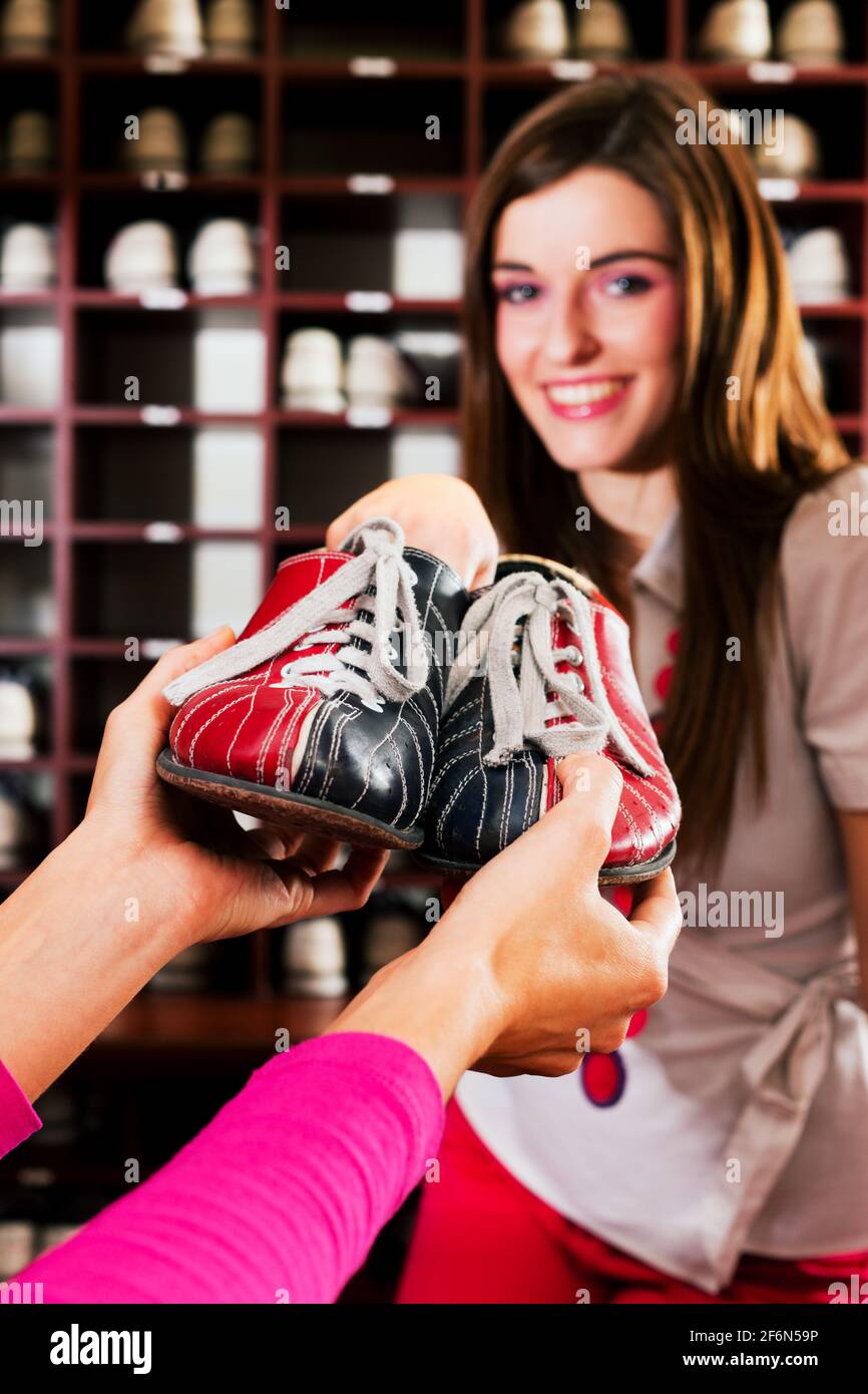 Une femme emprunte des chaussures pour jouer au bowling dans un club de  divertissement Photo Stock - Alamy