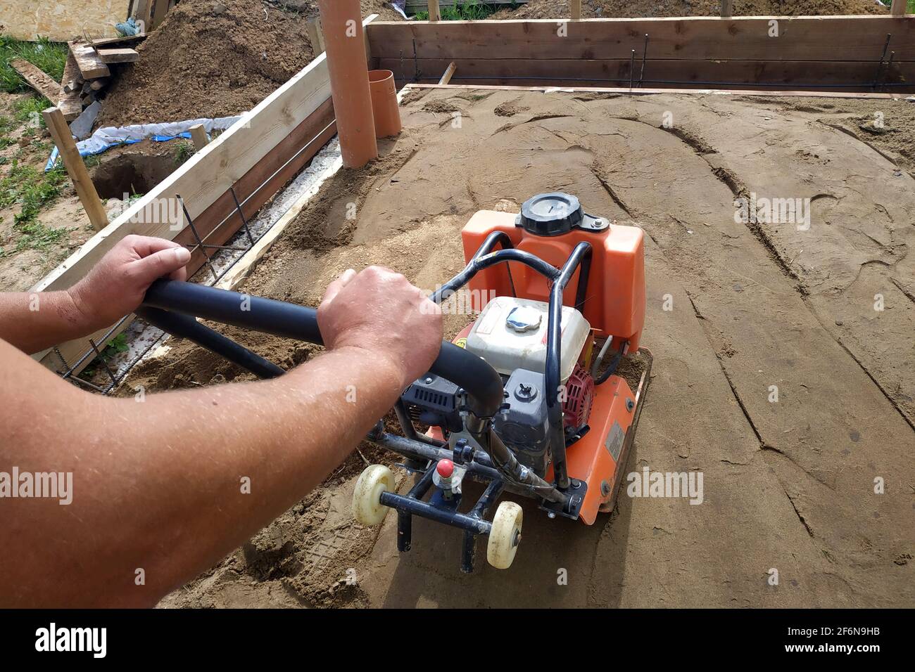 Travail avec une machine et un équipement vibrants, compactage du sol avec  une plaque vibrante.New Photo Stock - Alamy