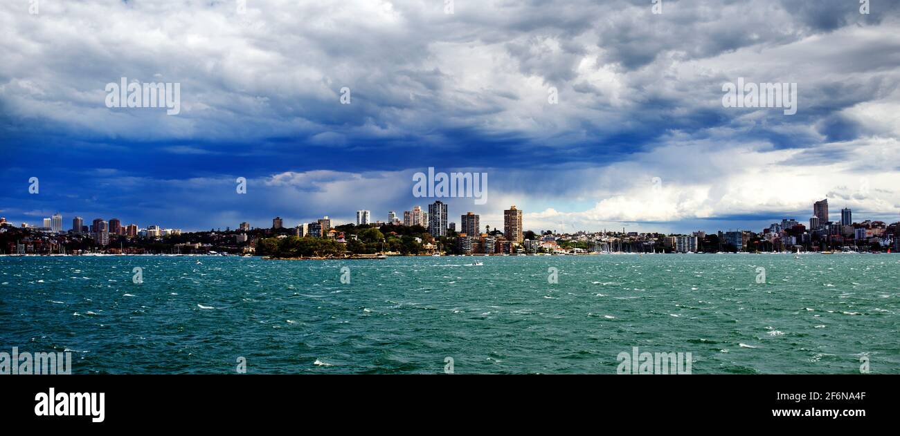 Vue panoramique depuis la mer, vue sur Sydney, où le nuage et la forte pluie s'installent au-dessus de la ville. Banque D'Images