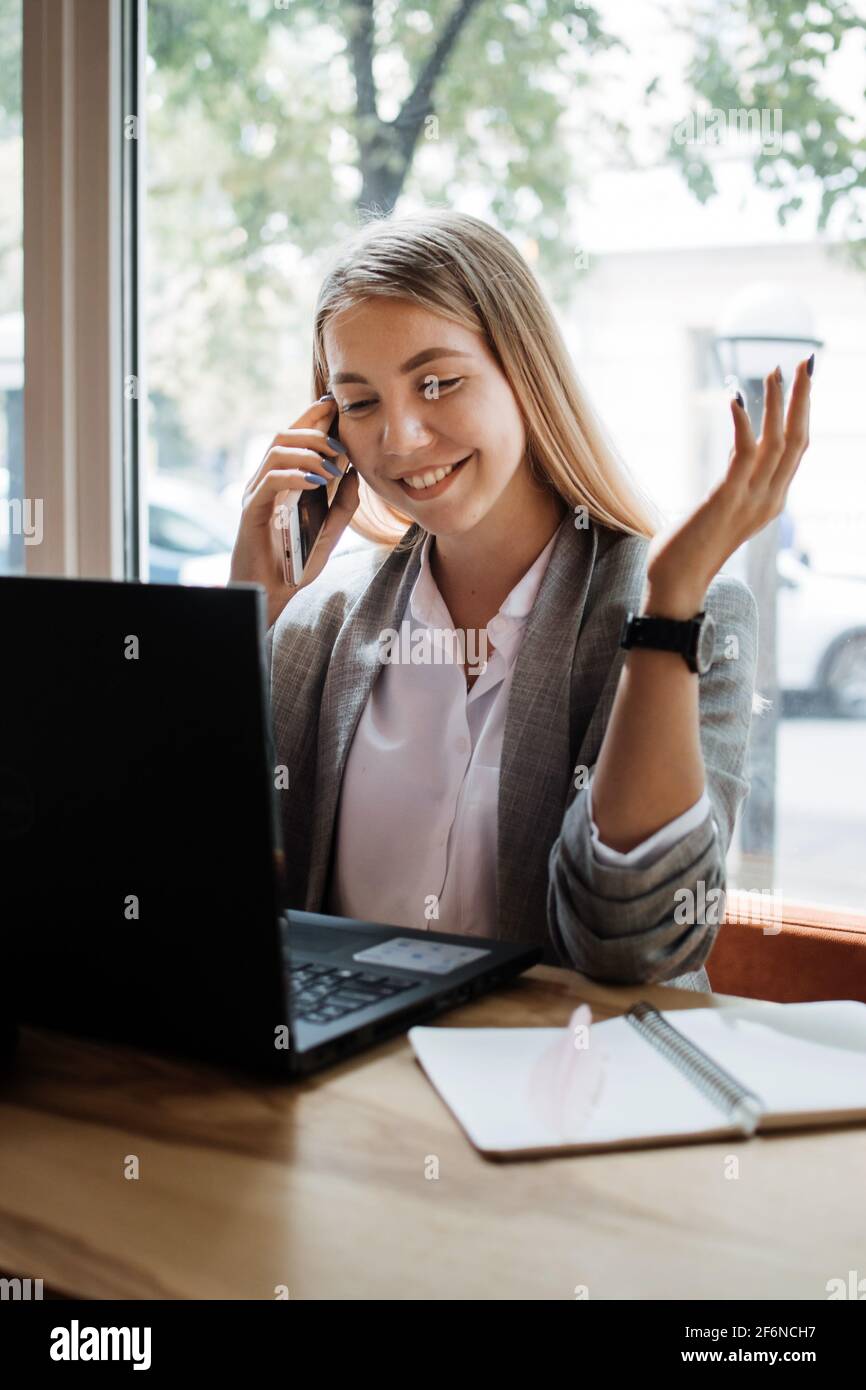 Assistant virtuel, entrepreneur indépendant, services administratifs aux clients, en fonctionnement à l'extérieur, bureau à domicile. Jeune femme parlant au téléphone et Banque D'Images