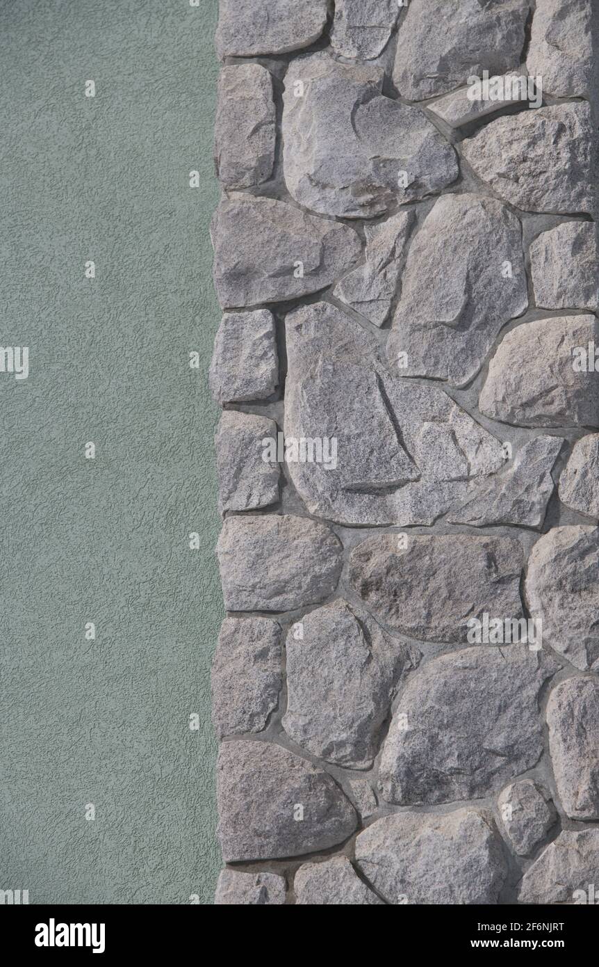 Les pierres de forme impaire ou les rochers s'adaptent ensemble comme un puzzle pour créer un mur de pierre construit maçonnerie maison mur extérieur arrière-plan ou papier peint Banque D'Images