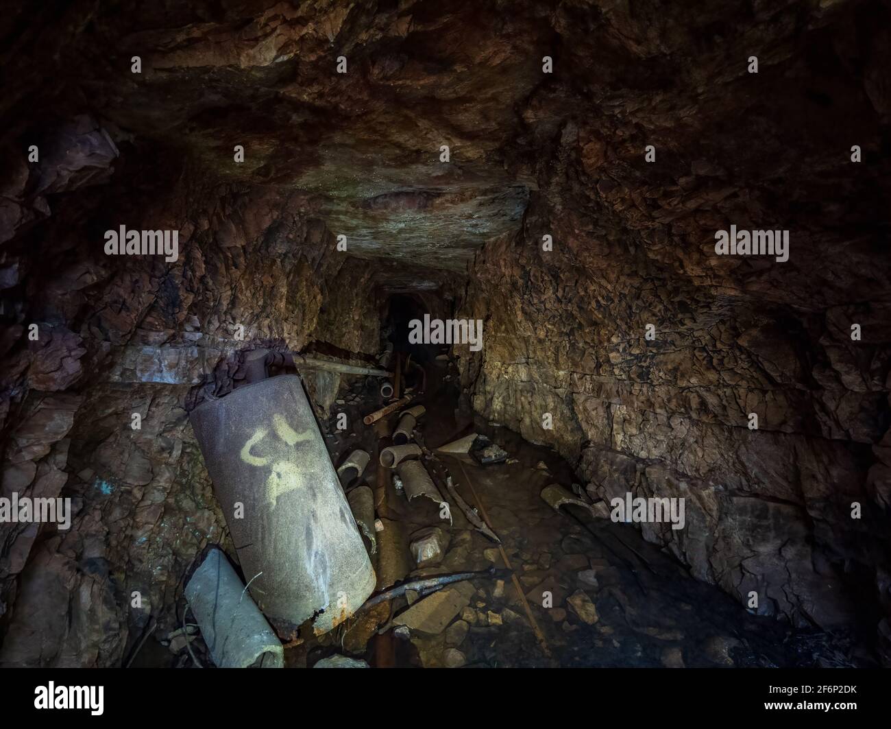 Ancien tunnel de mine abandonné avec de l'eau et des débris Banque D'Images
