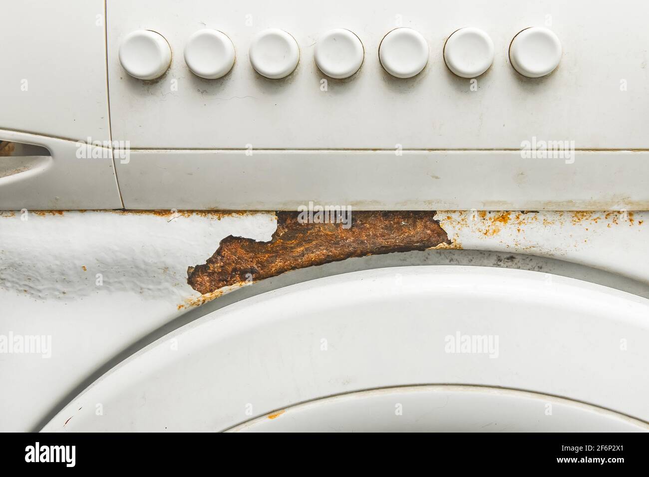 Le boîtier ou l'avant d'un ancien lave-linge blanc se rapproche avec des traces de rouille et un bandeau de commande. Banque D'Images