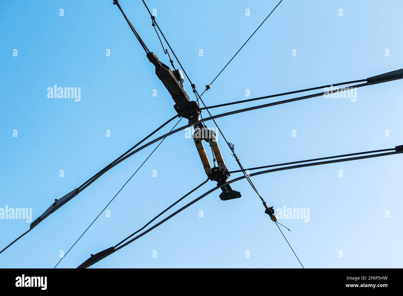 Lignes de transmission électrique aériennes sur fond bleu ciel. Câbles électriques industriels passant au-dessus de l'arrière-plan clair du ciel. Banque D'Images