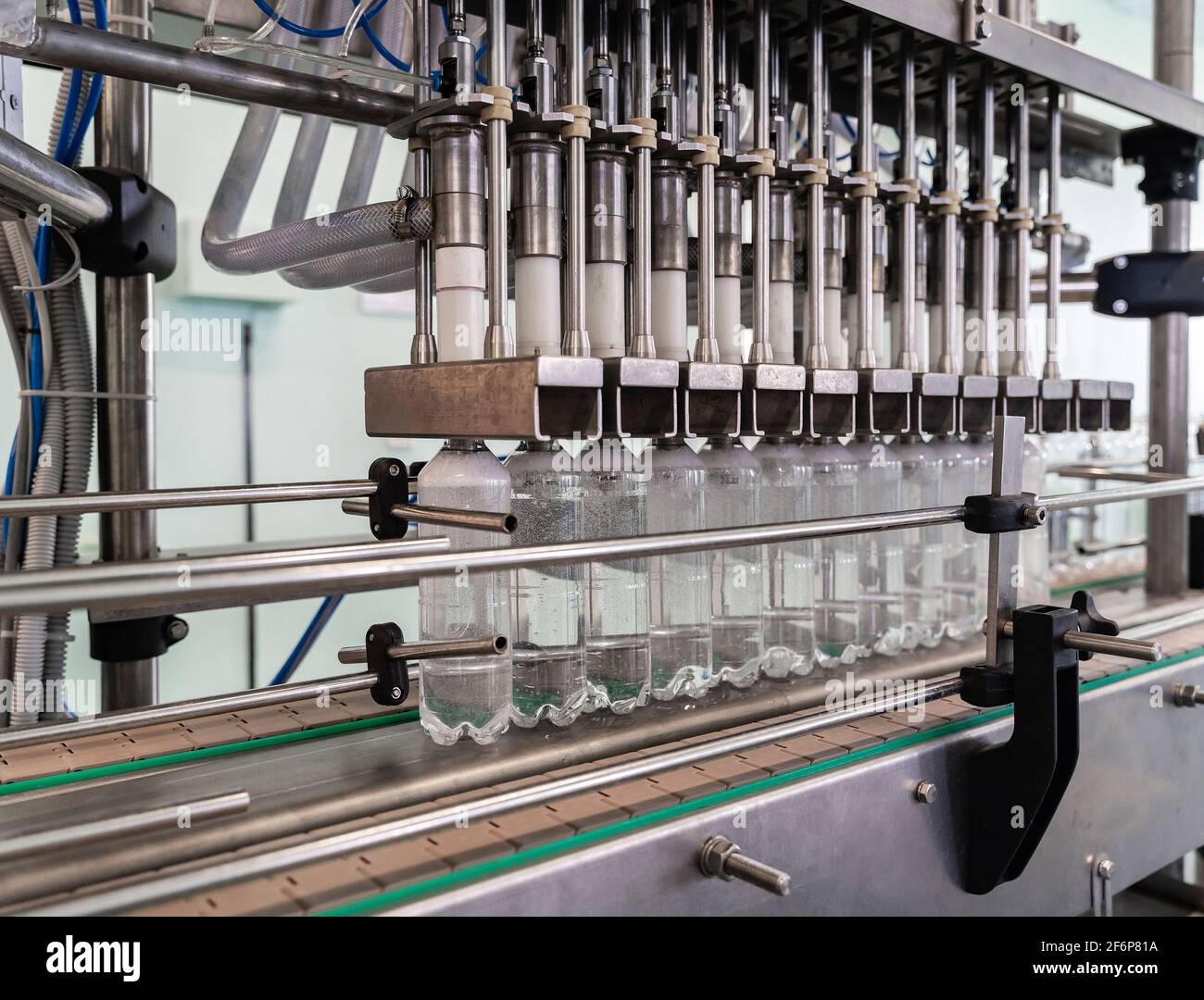 Convoyeur de remplissage d'eau dans des bouteilles en plastique. Ligne de production automatisée. Banque D'Images