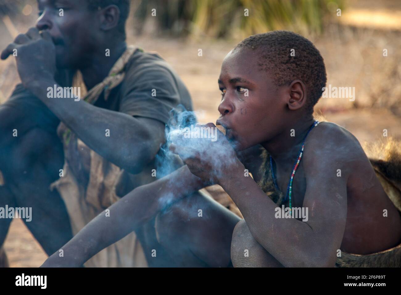 (10/15/2014) les Hadza sont utilisés pour socialiser autour du feu en fumant une pipe ou en jouant des instruments tribaux les Hadza sont un groupe ethnique tanzanien vivant autour du lac Eyasi. La population atteint près d'un millier de personnes; 300-400 vivent comme chasseurs-cueilleurs. Les Hadza n'ont aucune corrélation étroite avec aucune autre population. Ils ont été considérés comme une branche est-africaine du peuple Khoisan, principalement en raison du fait que leur langue a les POP typiques des langues Khoisan, mais des études récentes de recherche génétique suggèrent une proximité avec les Pygmées. Leur langue semble être isolée, sans rapport t Banque D'Images