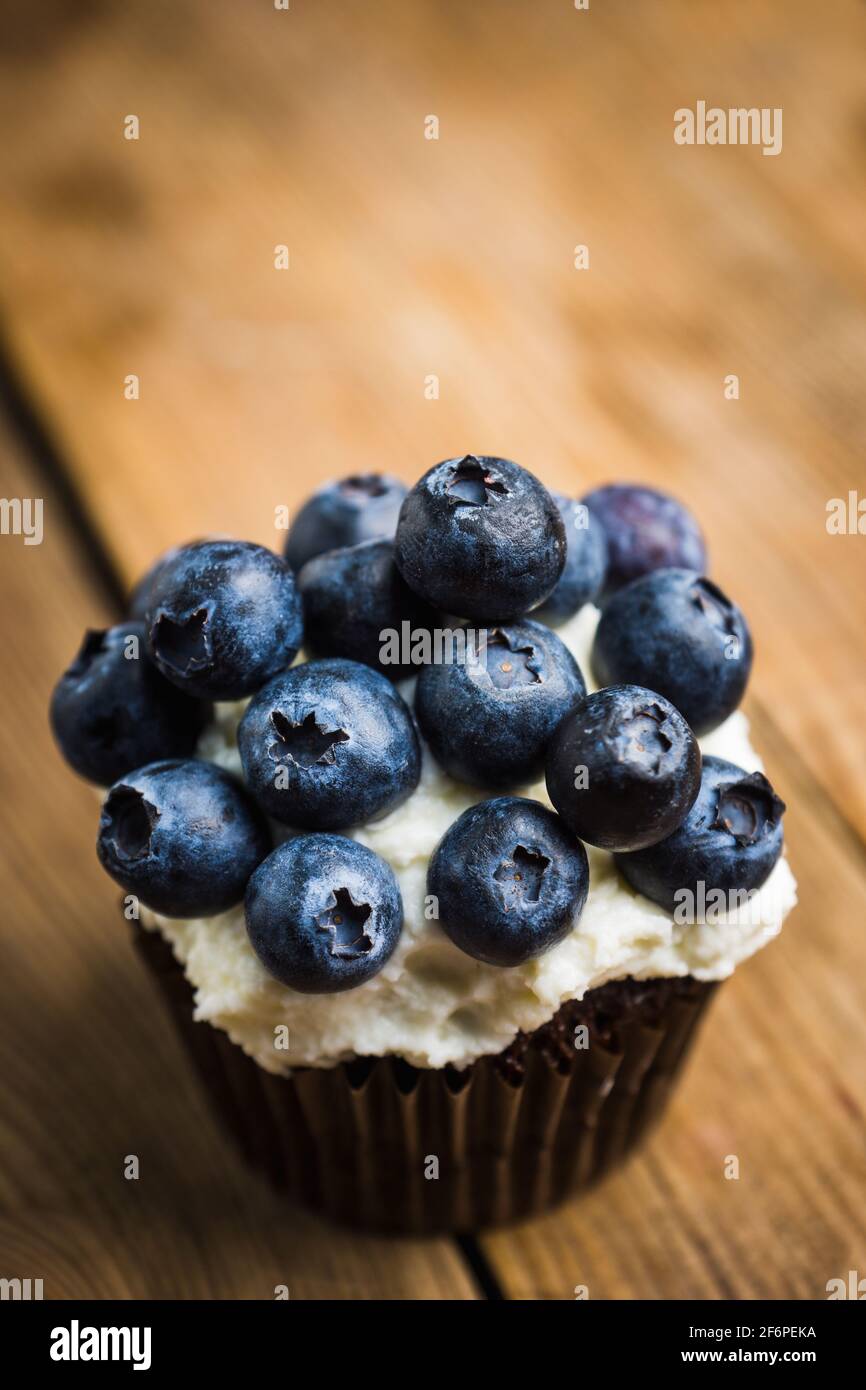 Muffin maison avec bleuets et fromage à la crème sur fond rustique. Mise au point sélective. Banque D'Images