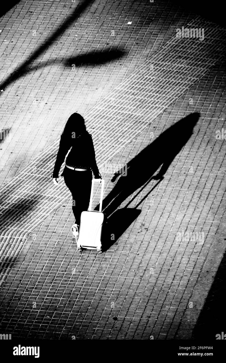 arrière, vue, arrière, femme, jeune, seul, ombre, nuit, sombre, voyageur, à  roulettes, valise, silhouette, noir, marche, glissé, glissé Photo Stock -  Alamy