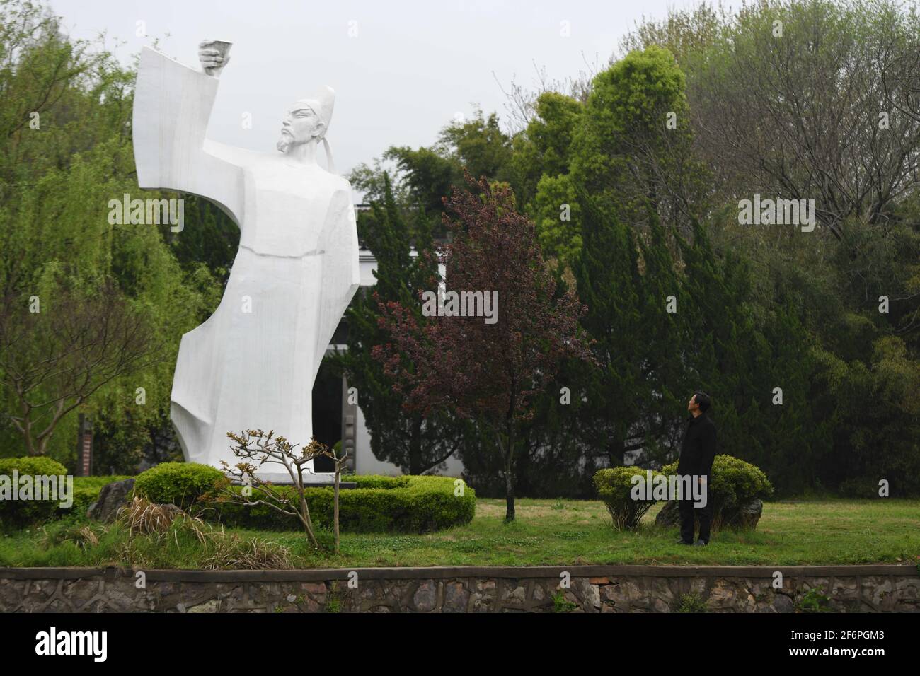 (210402) -- DANGTU, 2 avril 2021 (Xinhua) -- Gu Changxin observe une statue de Li Bai au parc culturel de Li Bai dans le comté de Dangtu de la ville de Maanshan, province d'Anhui en Chine orientale, 31 mars 2021. Le tombeau de Li Bai, un célèbre poète de la dynastie Tang (618-907), est situé au pied de la montagne Qingshan dans le comté de Dangtu de la ville de Maanshan. Après la mort de Li Bai à Dangtu, son bon ami Gu Lanxin a offert sa terre comme lieu de sépulture de Li Bai. Depuis, la famille du Gu est devenue le gardien de la tombe de Li Bai, qui continue jusqu'à ce jour. En 1985, Gu Changxin, 18 ans, est devenu le gardien de tombeau de la 49e génération. Banque D'Images