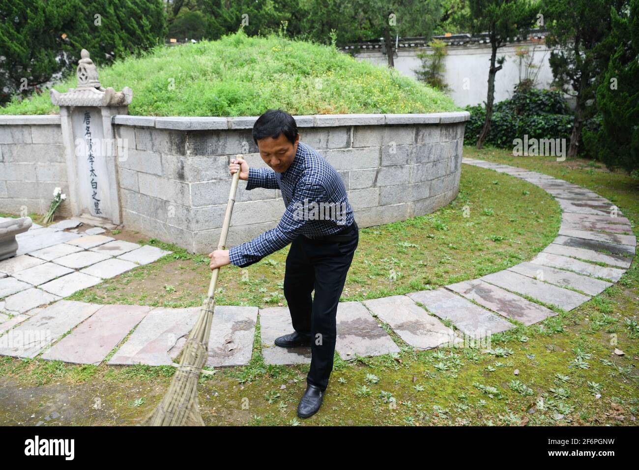 (210402) -- DANGTU, 2 avril 2021 (Xinhua) -- Gu Changxin nettoie la tombe de Li Bai au parc culturel de Li Bai, dans le comté de Dangtu de la ville de Maanshan, province d'Anhui en Chine orientale, 31 mars 2021. Le tombeau de Li Bai, un célèbre poète de la dynastie Tang (618-907), est situé au pied de la montagne Qingshan dans le comté de Dangtu de la ville de Maanshan. Après la mort de Li Bai à Dangtu, son bon ami Gu Lanxin a offert sa terre comme lieu de sépulture de Li Bai. Depuis, la famille du Gu est devenue le gardien de la tombe de Li Bai, qui continue jusqu'à ce jour. En 1985, Gu Changxin, 18 ans, est devenu le gardien de tombeau de la 49e génération. Pour Banque D'Images