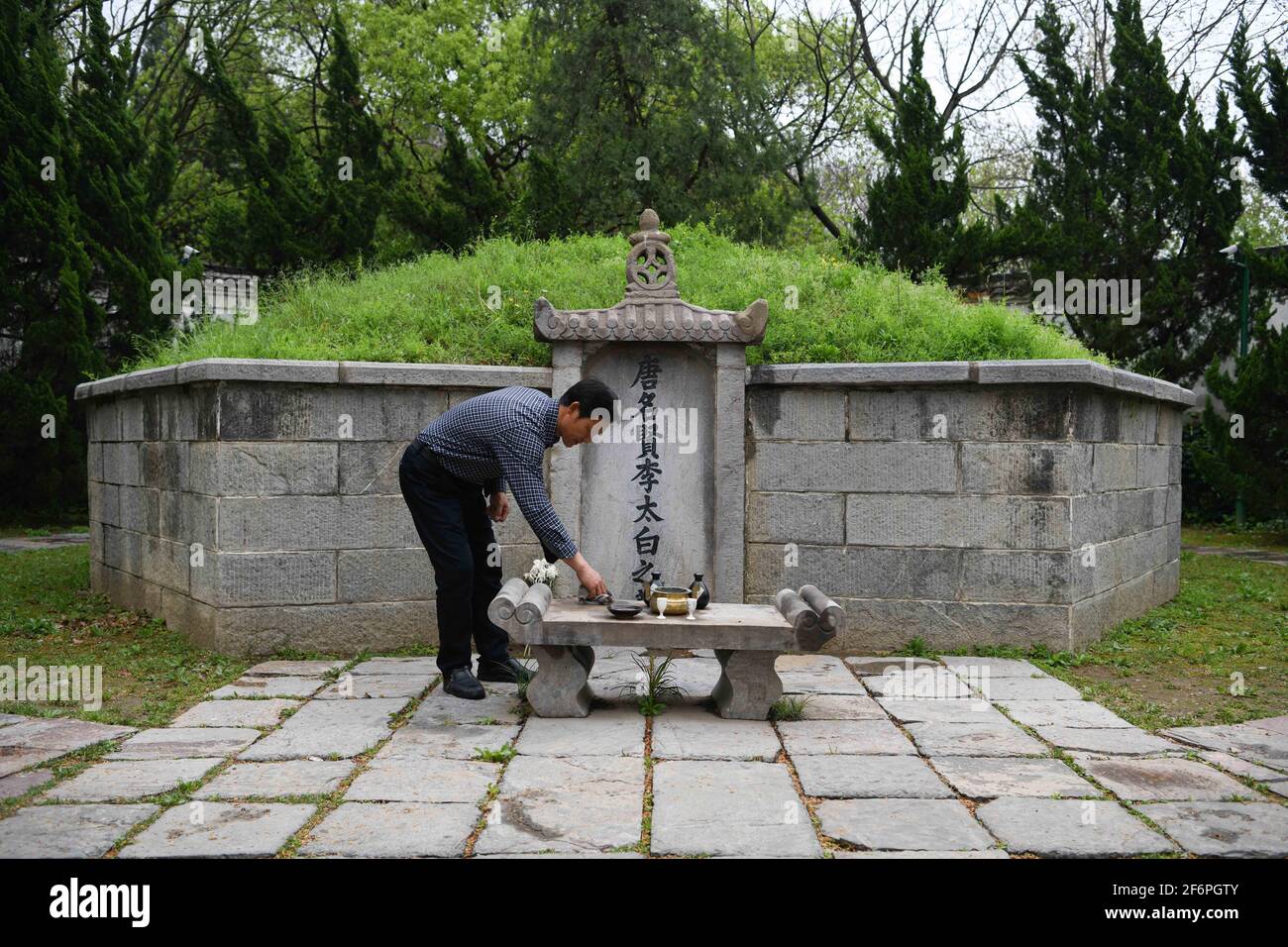 (210402) -- DANGTU, 2 avril 2021 (Xinhua) -- Gu Changxin nettoie l'autel de la tombe de Li Bai dans le parc culturel de Li Bai dans le comté de Dangtu de la ville de Maanshan, province d'Anhui en Chine orientale, 31 mars 2021. Le tombeau de Li Bai, un célèbre poète de la dynastie Tang (618-907), est situé au pied de la montagne Qingshan dans le comté de Dangtu de la ville de Maanshan. Après la mort de Li Bai à Dangtu, son bon ami Gu Lanxin a offert sa terre comme lieu de sépulture de Li Bai. Depuis, la famille du Gu est devenue le gardien de la tombe de Li Bai, qui continue jusqu'à ce jour. En 1985, Gu Changxin, 18 ans, est devenu le tombeau k de la 49e génération Banque D'Images