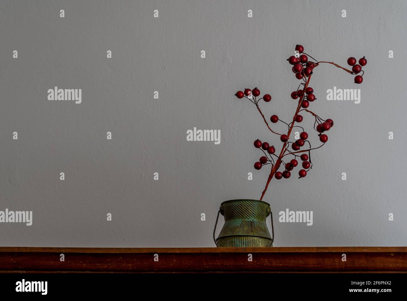 Décoration maison - plante avec baies rouges et un vieux tasse Banque D'Images