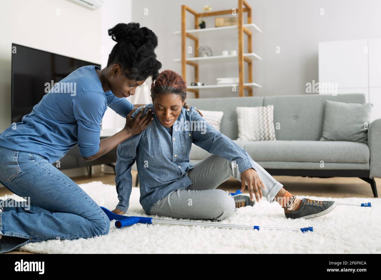 Risque de glissade et de chute. Aider la femme africaine Banque D'Images