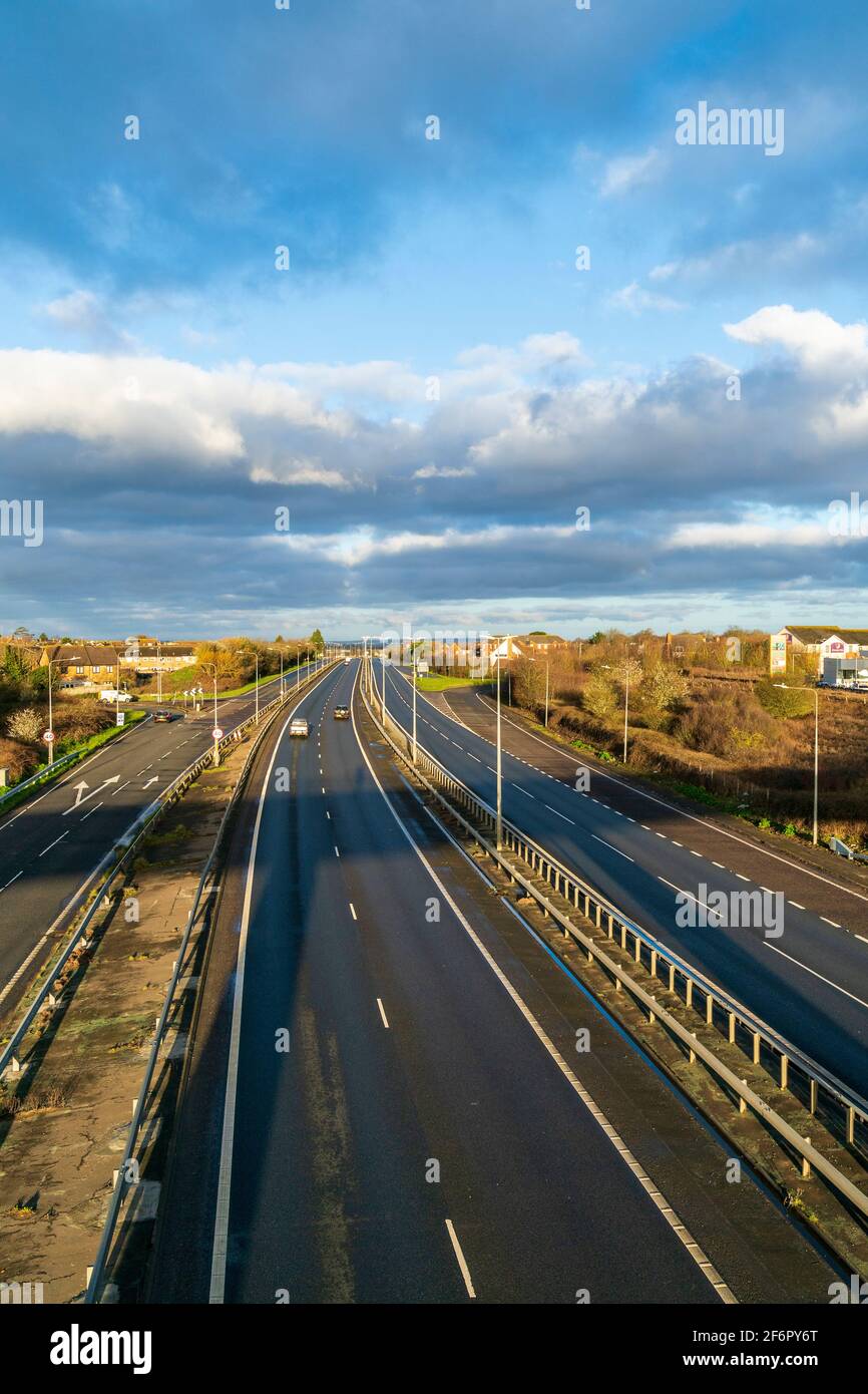 Vue en hauteur le long de la route principale avec quelques voitures tôt le matin. Route principale britannique, A299, Thanet Way, route à deux voies avec éclairage central. Banque D'Images