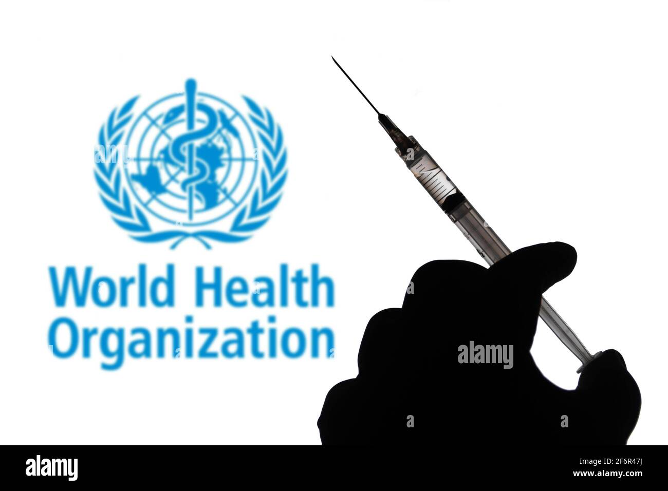 Brésil. 30 mars 2021. Dans cette illustration, une main tient une seringue médicale avec le logo de la société de l'Organisation mondiale de la Santé (OMS) affiché sur un écran en arrière-plan. Credit: Rafael Henrique/SOPA Images/ZUMA Wire/Alamy Live News Banque D'Images