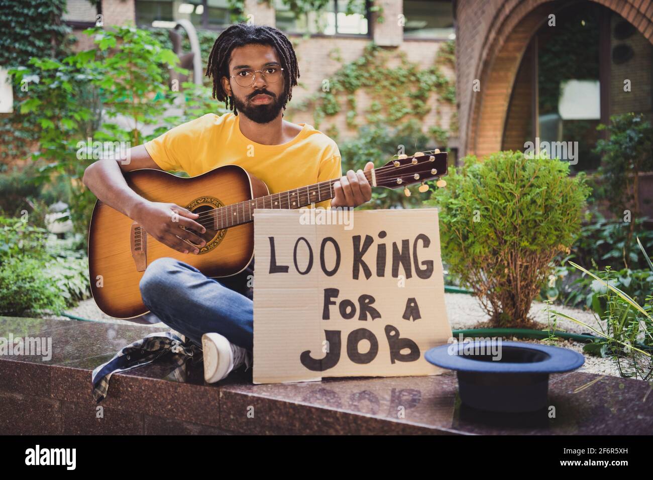 Photo portrait d'un gars jouant de la guitare assis triste sur le vert rue  en été à la recherche d'emploi besoin d'argent Photo Stock - Alamy