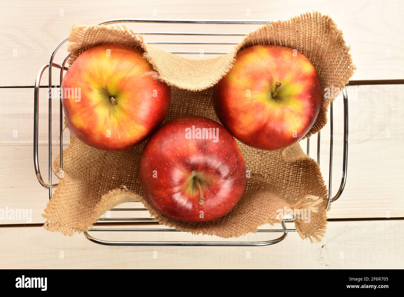 Un peu biologique, frais, mûr, juteux, savoureux, Pommes Red Jonathan, gros  plan, dans un panier en métal avec une serviette en jute, sur un plan de  travail en bois blanc Photo Stock -