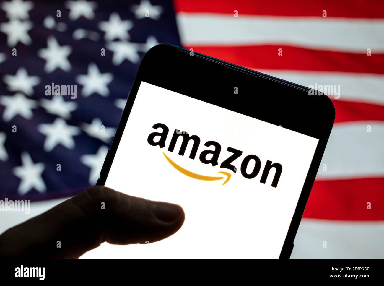 Dans cette illustration, le logo Amazon de l'entreprise américaine de  commerce électronique et de cloud computing est visible sur un appareil  mobile Android avec un drapeau américain (États-Unis), communément appelé  États-Unis (États-Unis