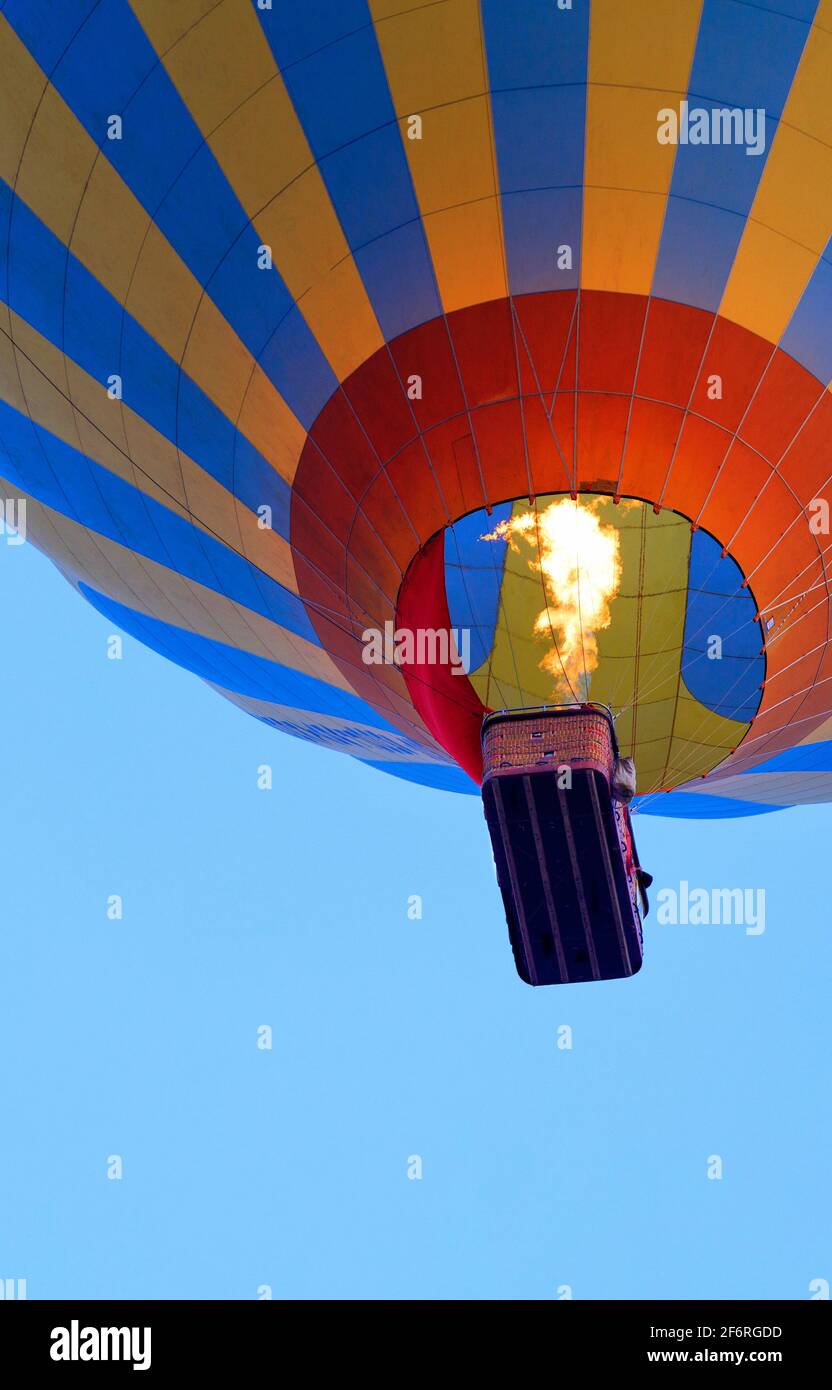 Fragment d'un ballon avec un panier et une flamme de feu provenant d'un brûleur qui chauffe l'air. Banque D'Images