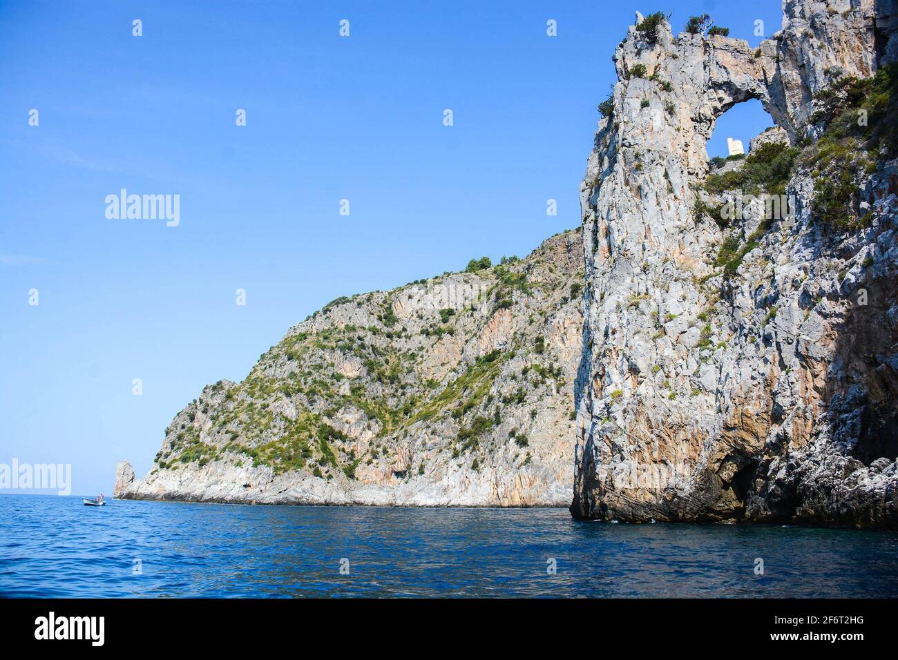 Vue sur la tour de Saracen restaurée à travers le cercle naturel de la falaise à Palinuro en Italie, visible seulement de la mer et de Capo Spartivento. Banque D'Images
