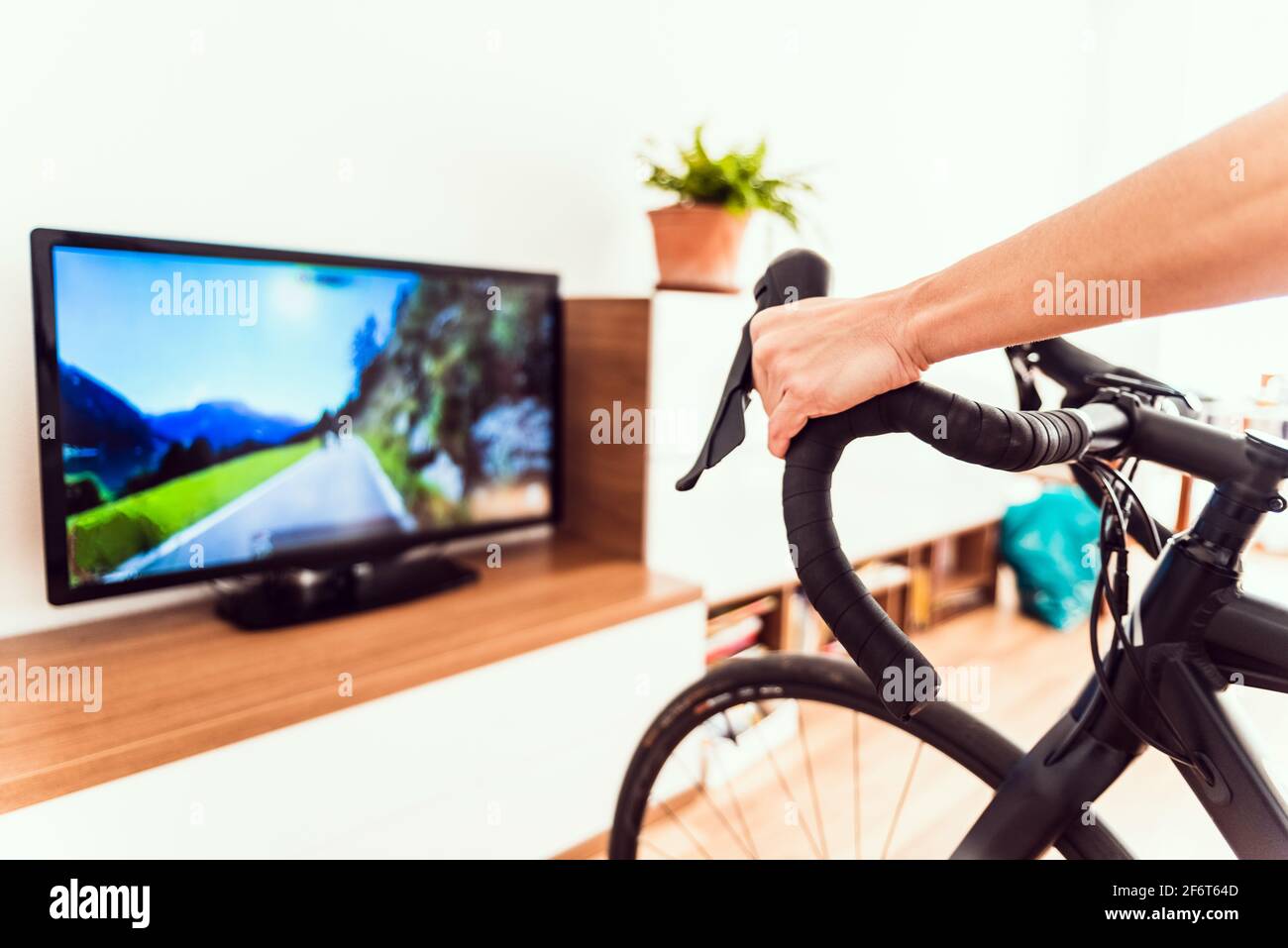 Femme s'exerce à l'intérieur en utilisant son vélo pour une course virtuelle  Photo Stock - Alamy