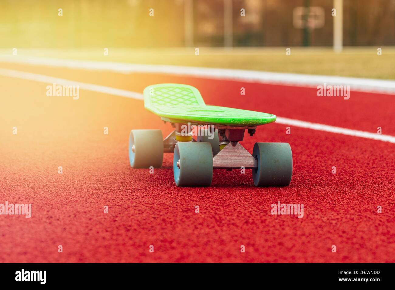 Green Penny Board est sur la piste de l'école stade Banque D'Images